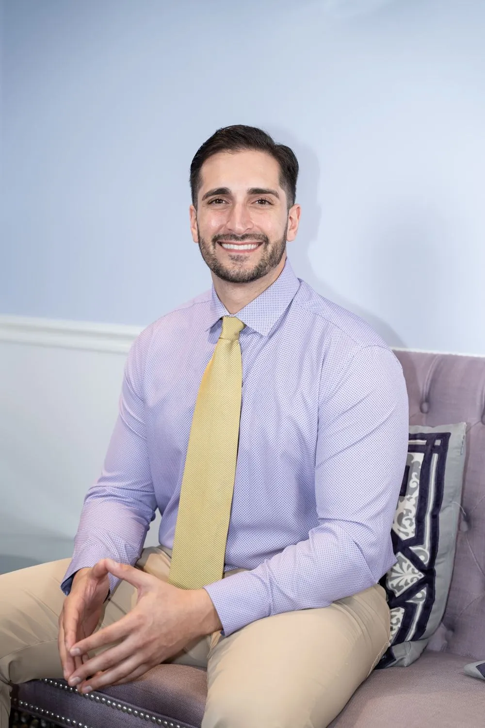 Dr. Justin Hosseini seated in a lilac waiting area
